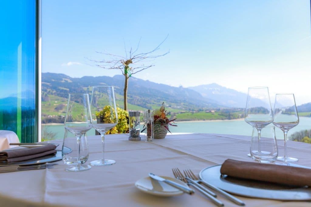 Table dressée devant la baie vitrée, vue sur le lac